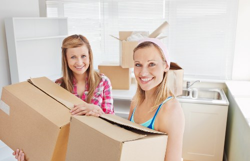 Two movers loading furniture for a local Southfields move